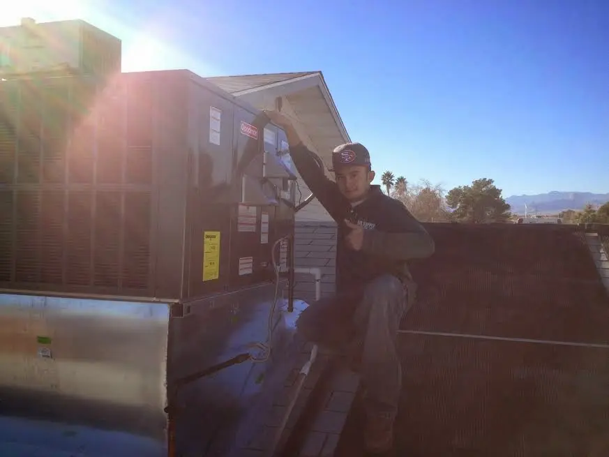 HVAC technician performing Boiler Repair on a rooftop unit in Escondido